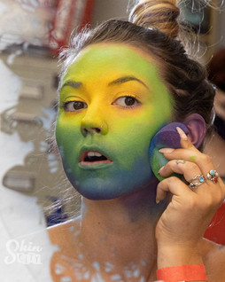 A model applying face paint to herself