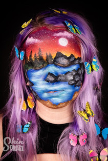 A face paint model with a landscape painted on
